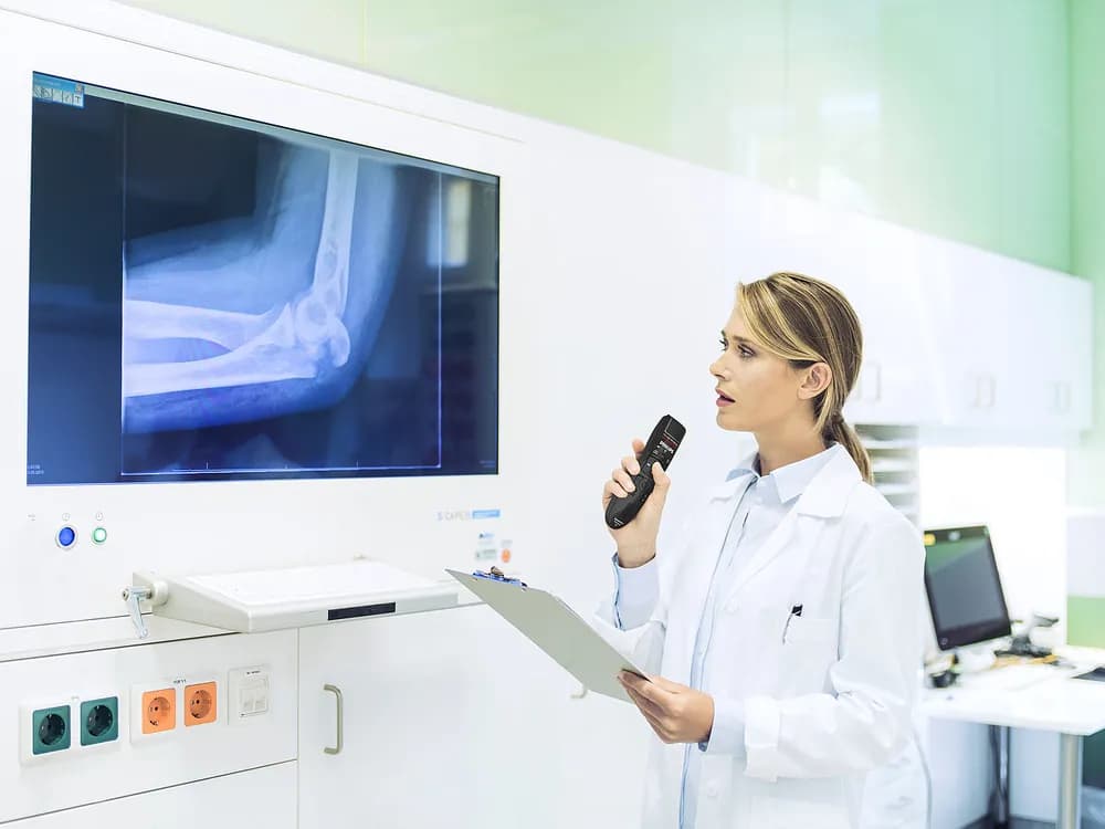 Physician reviewing an x-ray while using Philips SpeechMike speech recognition